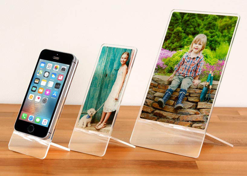 acrylic phone stand of different sizes on a wood surface